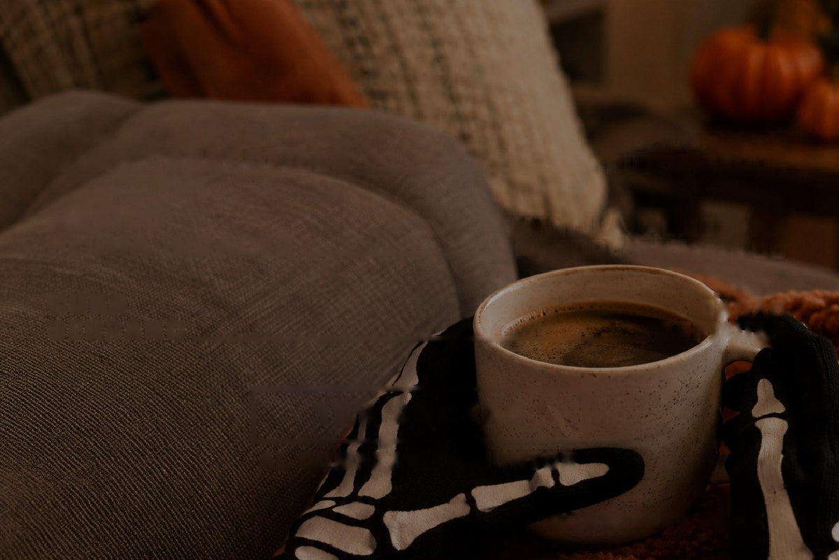 Taza de café sobre una manta en el sofá